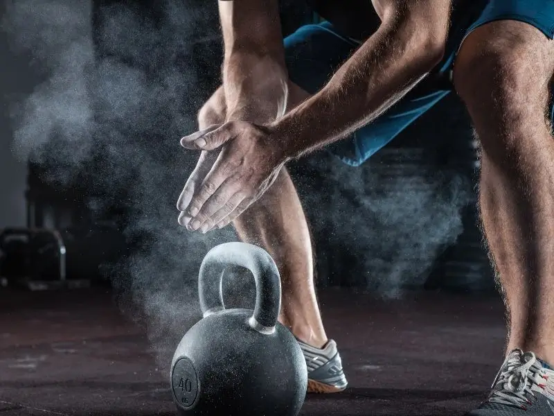 Person with chalked hands and kettlebell