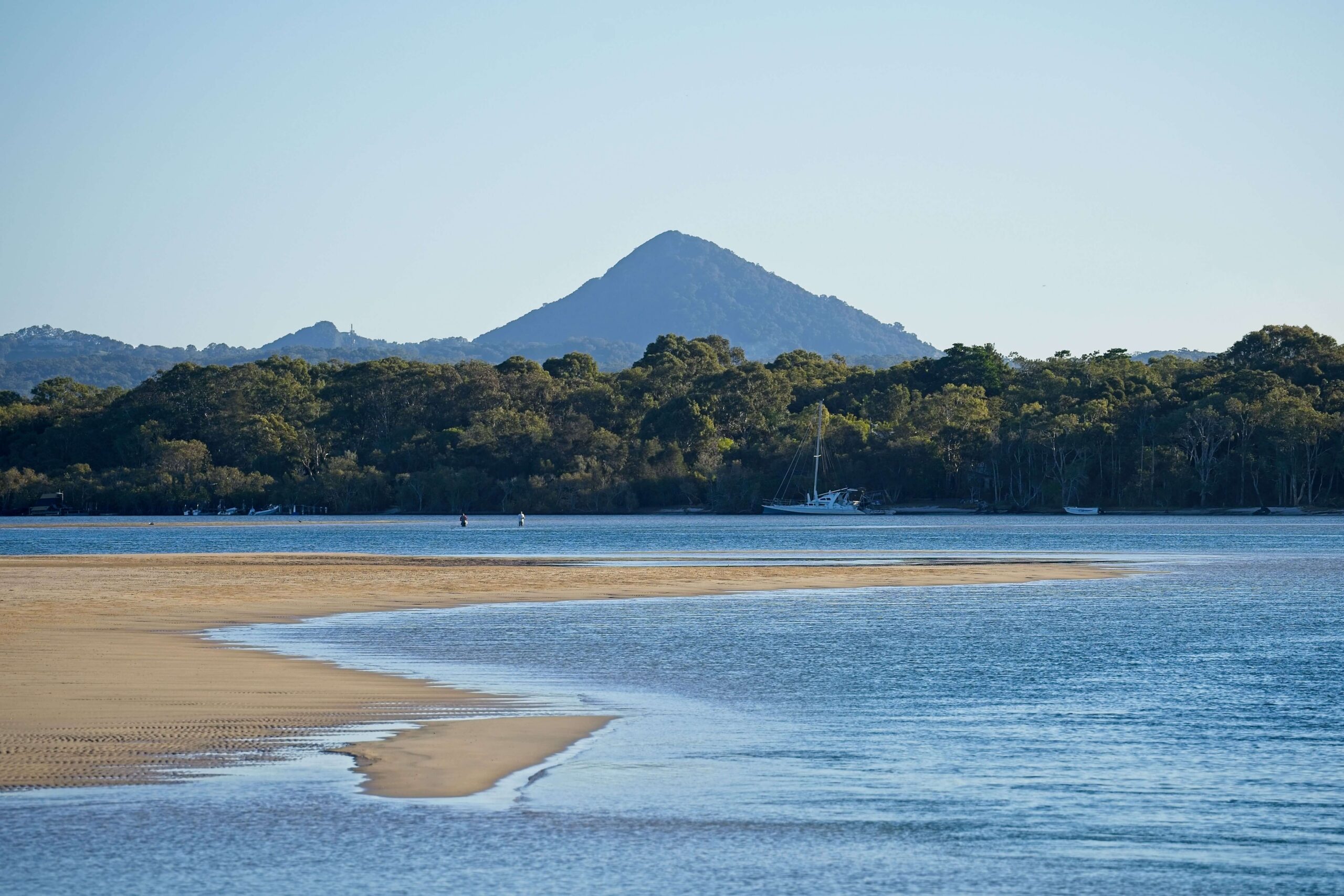 Noosa Heads, Australia (1) Noosa Heads, Australia with a beach, forest, and sailboat at dusk